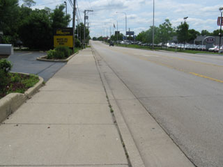 The sidewalk where the kids walked past the car dealerships.